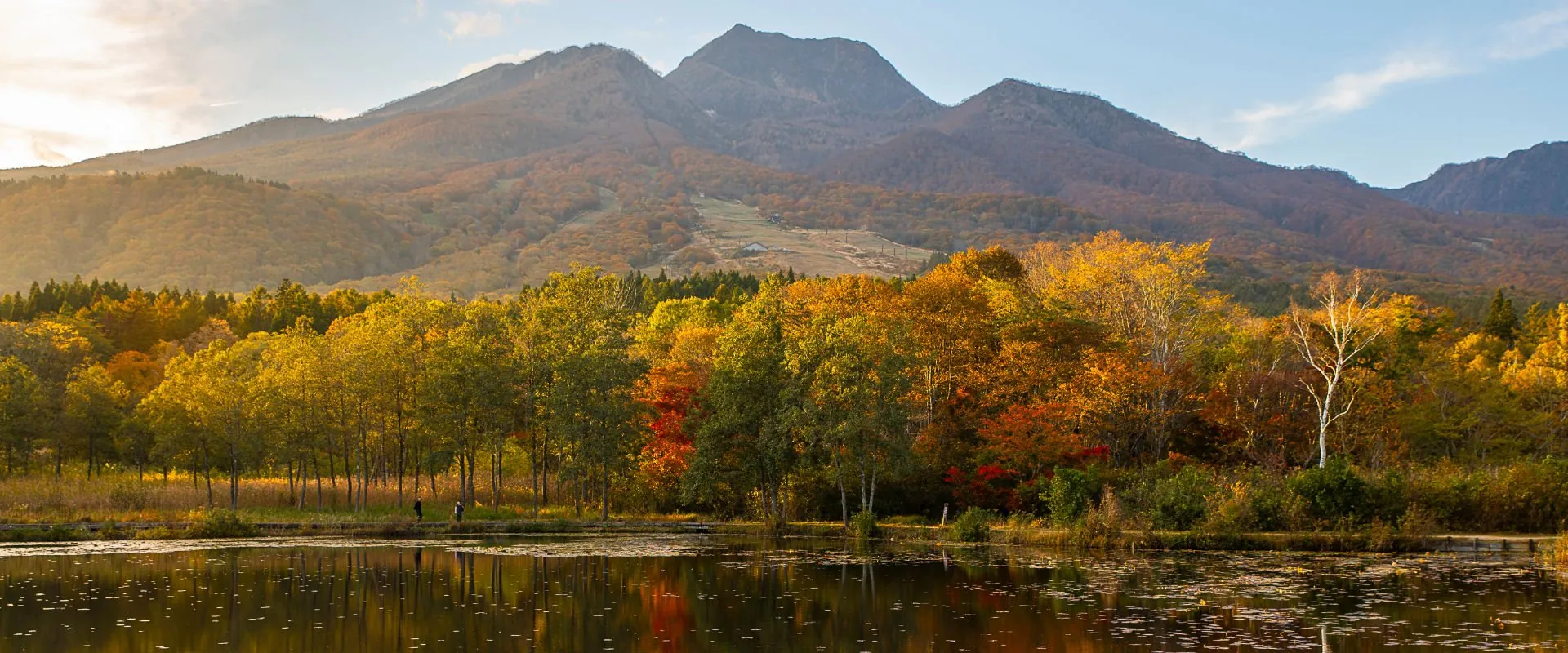 秋の妙高山と、紅葉に囲まれた池
